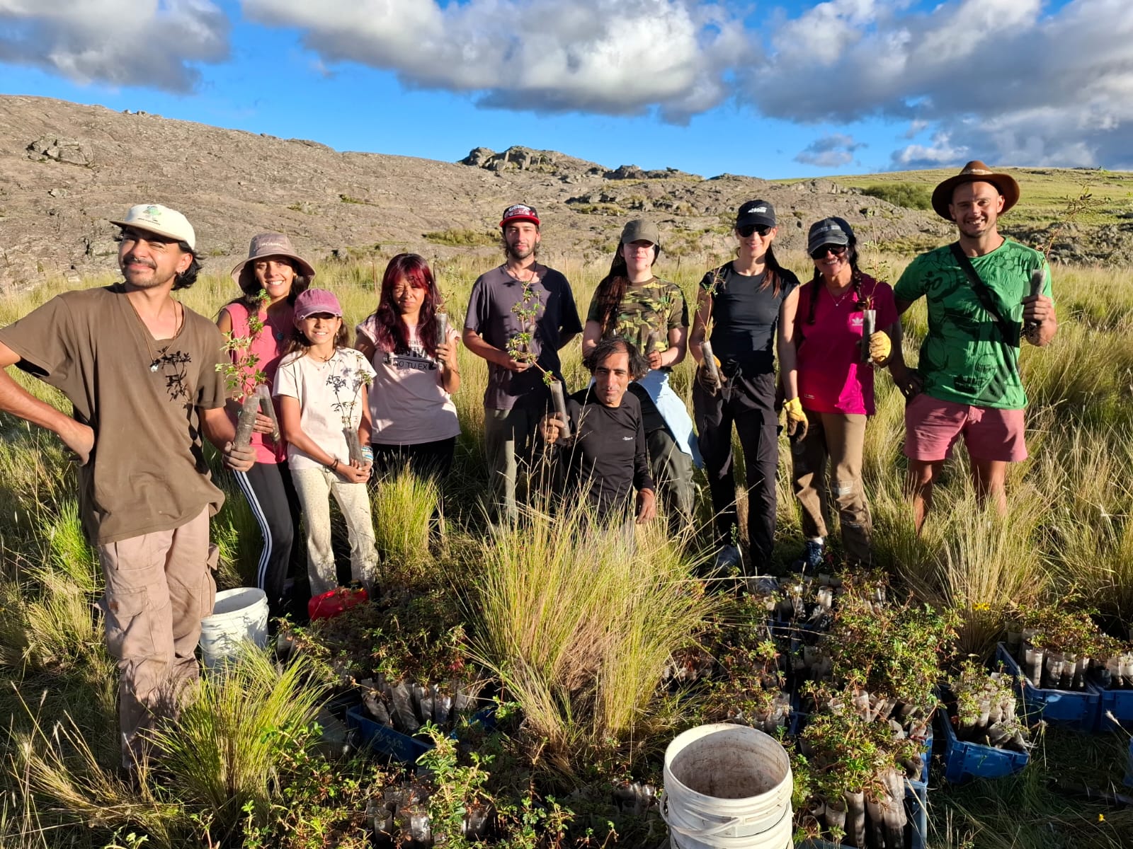 Grupo de voluntariado con plantines nativos durante una jornada de reforestación en las sierras